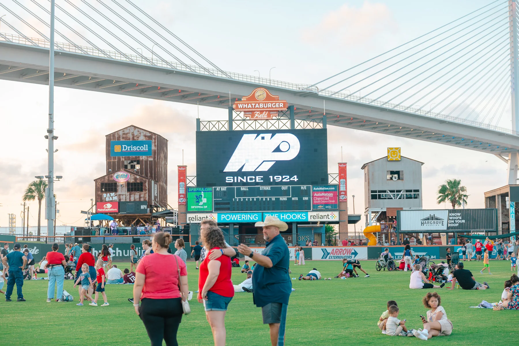 Community gathering at the baseball field beneath the Harbor Bridge