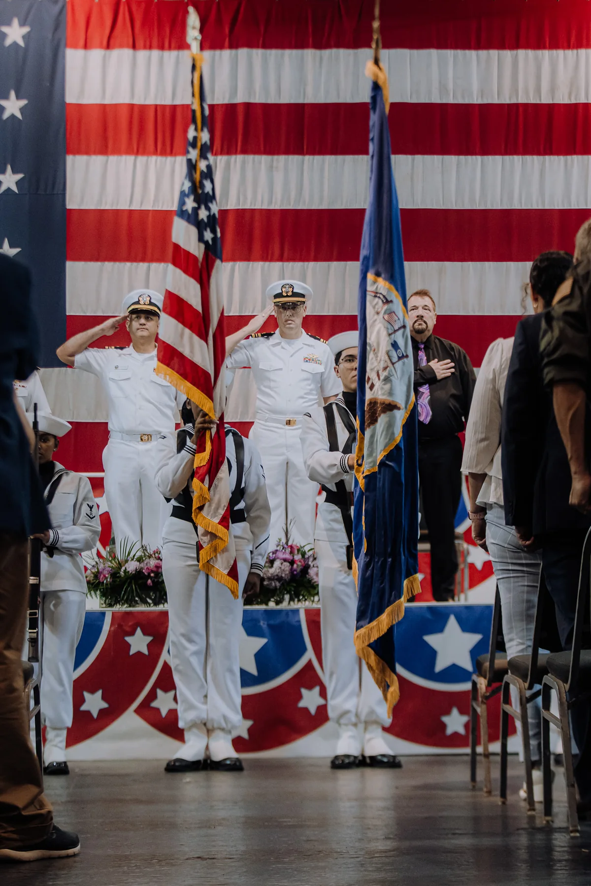Navy color guard presented before a large American flag